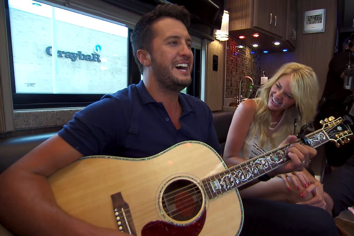 luke bryan playing guitar next to fan