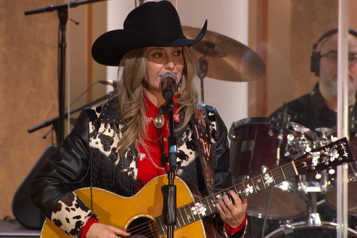 Lainey Wilson singing and playing guitar
