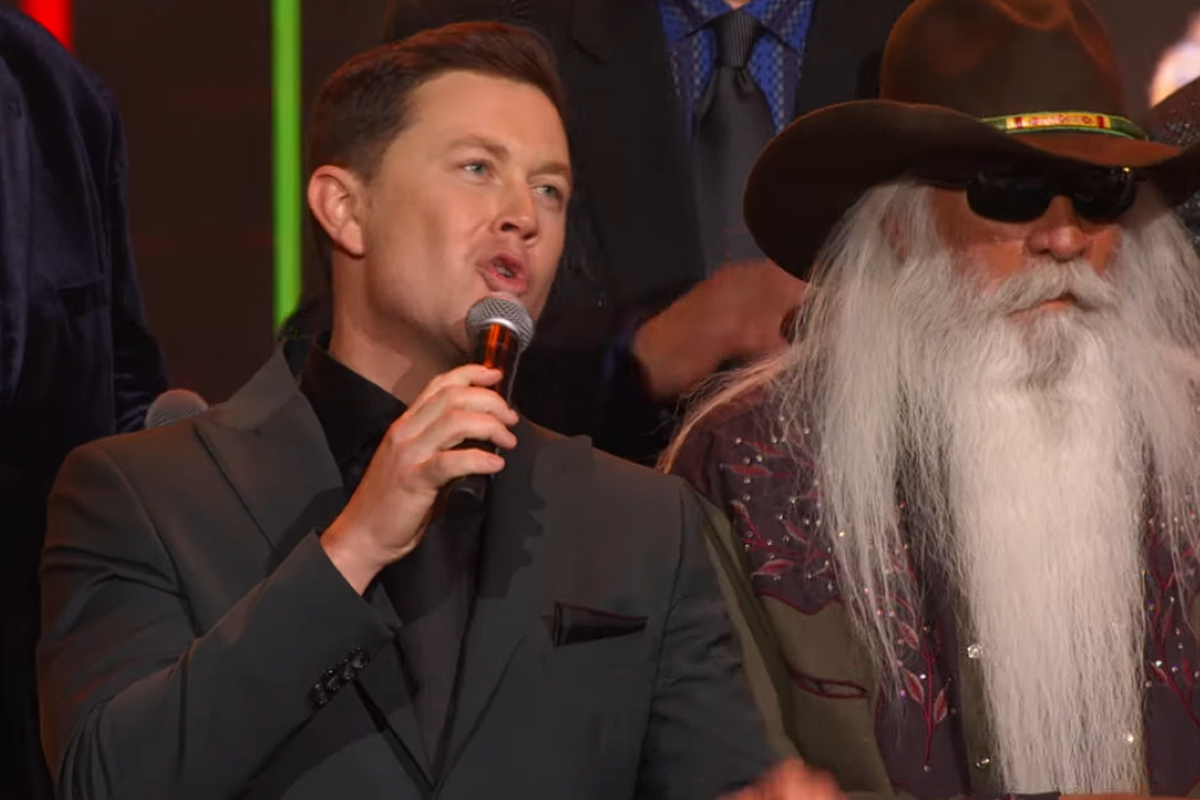 Scotty McCreery singing into microphone at the Opry