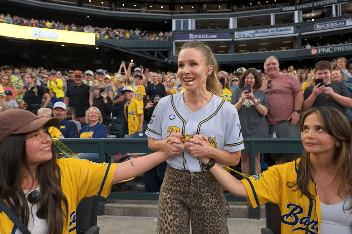 Kristen Bell holding two Savannah Bananas fans' hands
